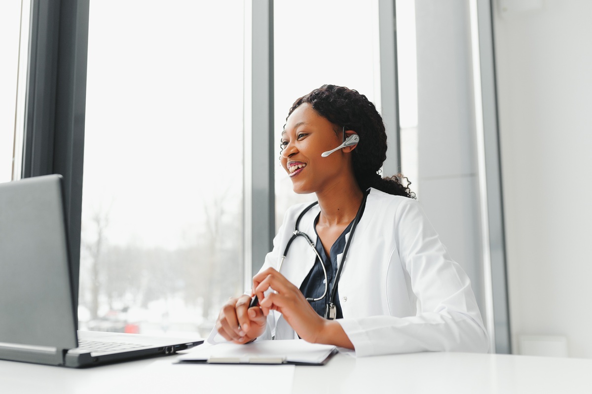 Confident female doctor smiling and listening through a headset.